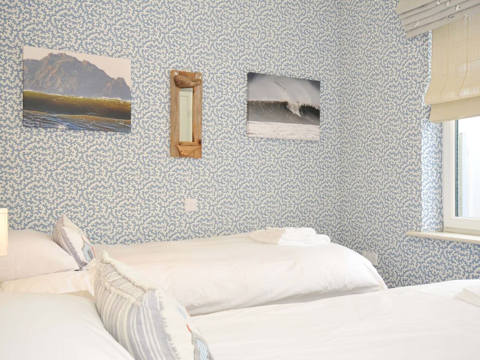 A bedroom with two beds and wall decorations at The Point in Polzeath