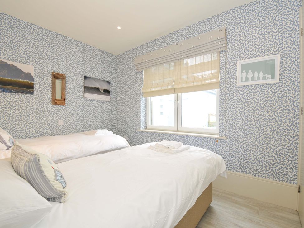 A bedroom with two beds and a window at The Point in Polzeath