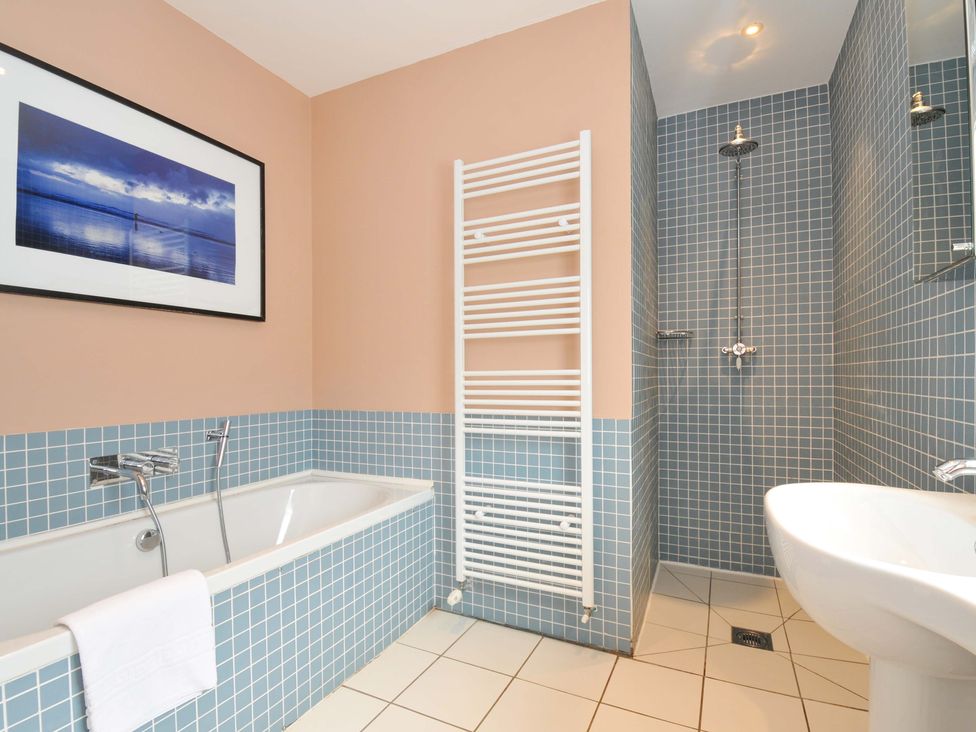 A bathroom with a bathtub, shower, toilet, and sink at The Point in Polzeath