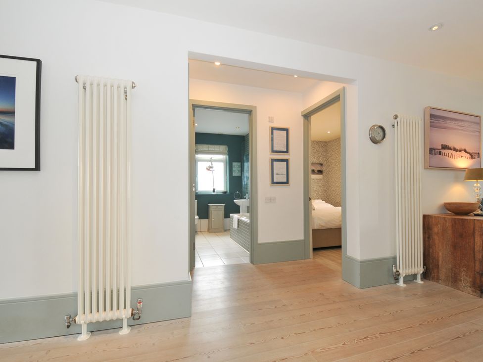 A hallway with a radiator and doors leading to other rooms at The Point in Polzeath