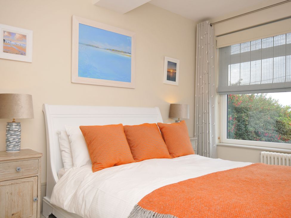 A bedroom with a bed and bedside lamp at The Point in Polzeath