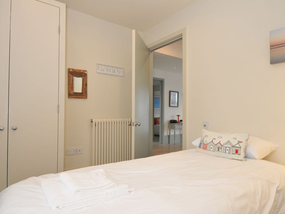 A bedroom with a bed and wardrobe at The Point in Polzeath