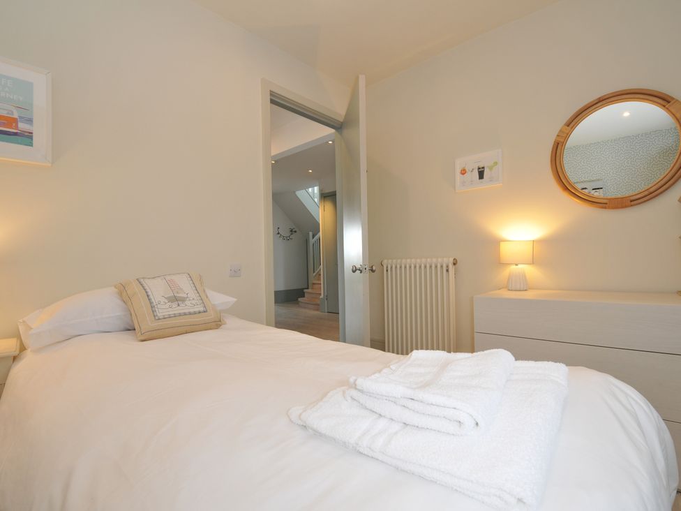 A bedroom with a bed and mirror at The Point in Polzeath