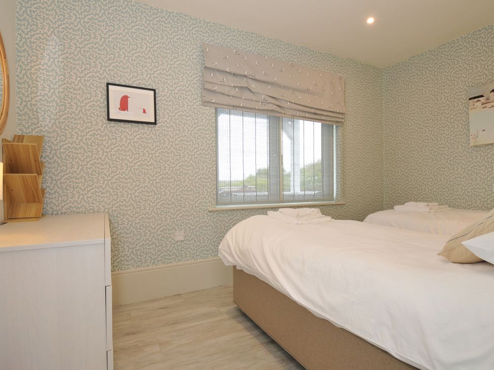 A bedroom with two beds and a window at The Point in Polzeath