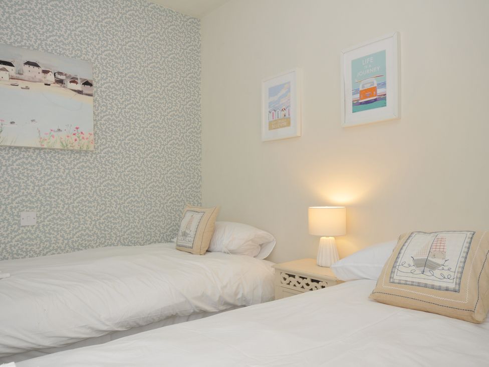 A bedroom with two beds and wall art at The Point in Polzeath