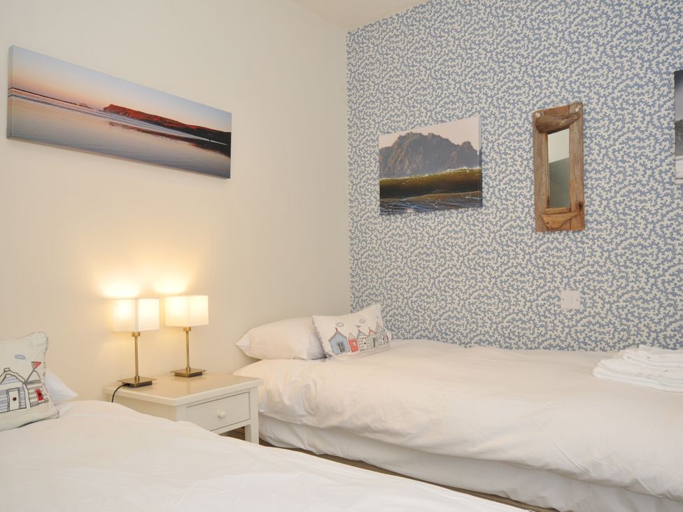 A bedroom with twin beds and lamps at The Point in Polzeath