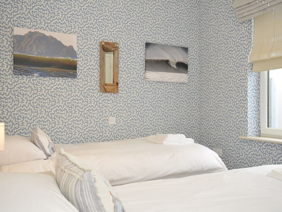 A bedroom with two beds and pictures on the wall at The Point in Polzeath