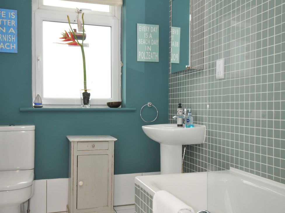 A bathroom with a toilet, basin, and bathtub at The Point in Polzeath