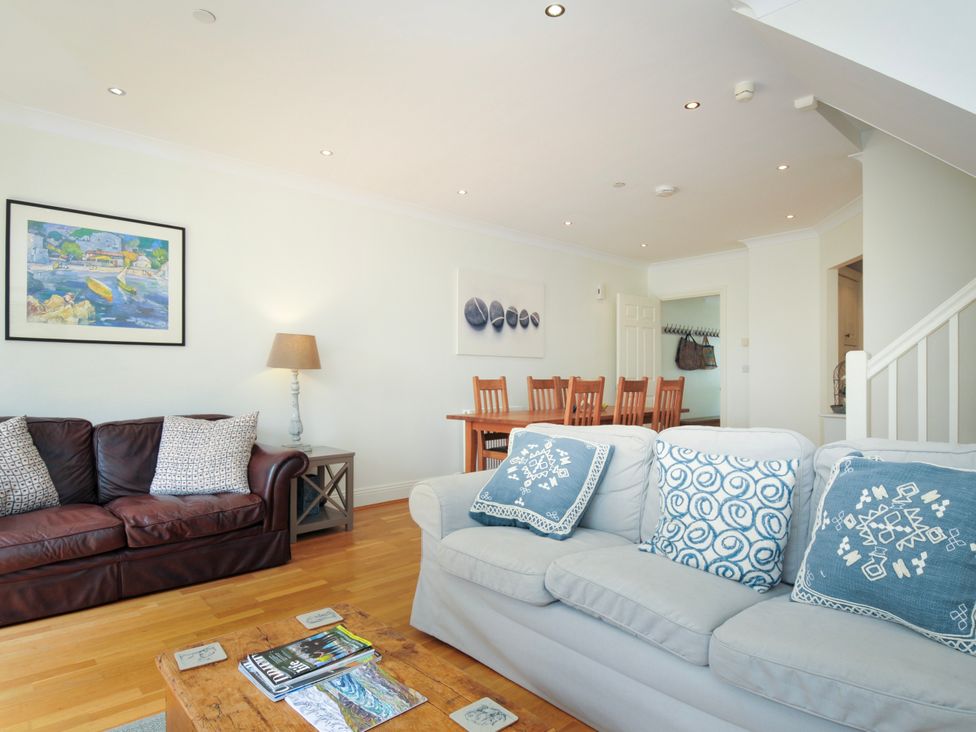 A living room with two sofas a wooden coffee table and a dining table with chairs at Lowenna Manor 3 Rock