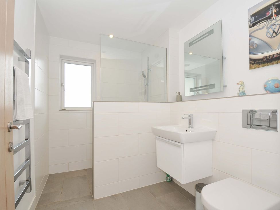 A bathroom with a shower, washbasin and toilet at Stepper Point in Polzeath