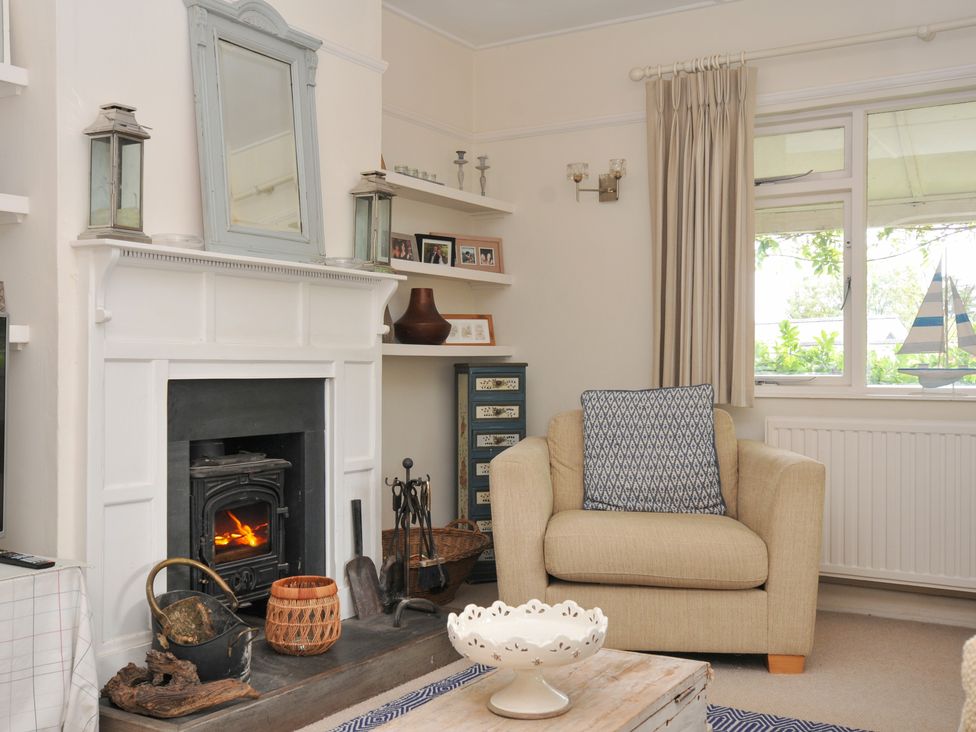 A living room with a fireplace and armchair at Sandy Lodge Rock