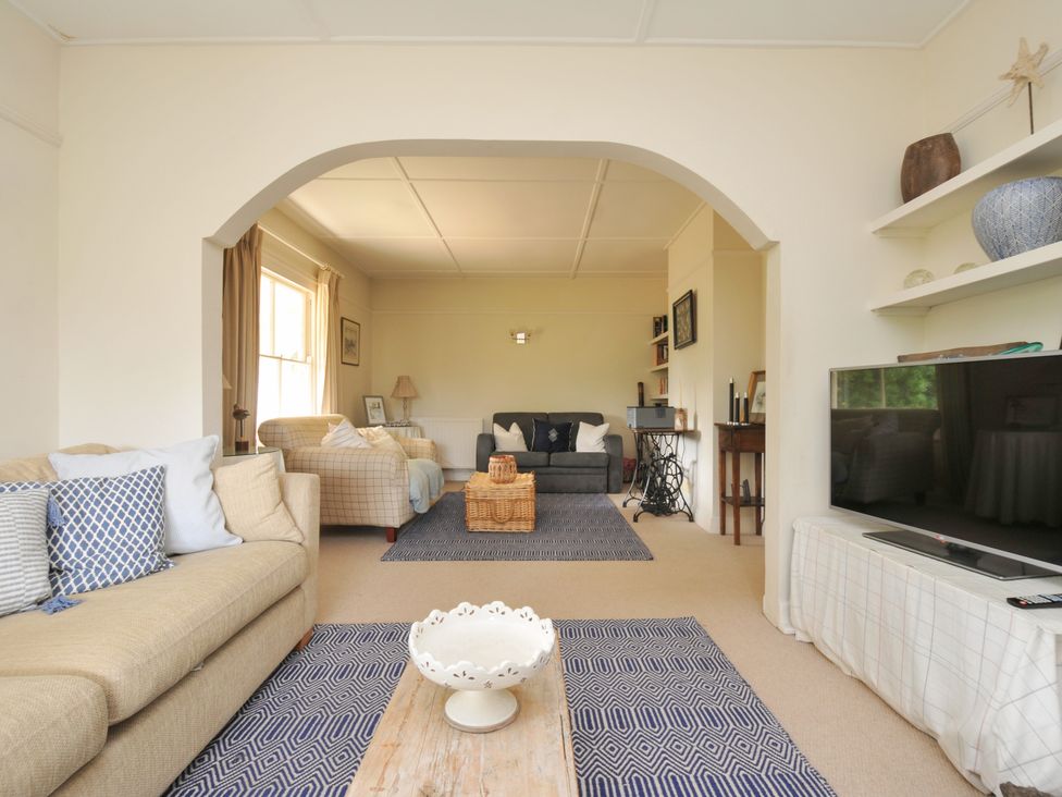 A living room with a sofa and a television at Sandy Lodge Rock