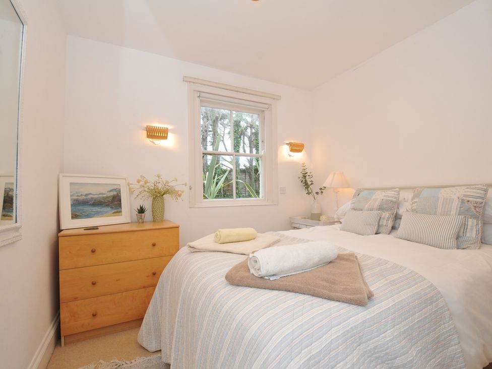 A bedroom with a bed, chest of drawers, and a window at Sandy Lodge Rock in Rock