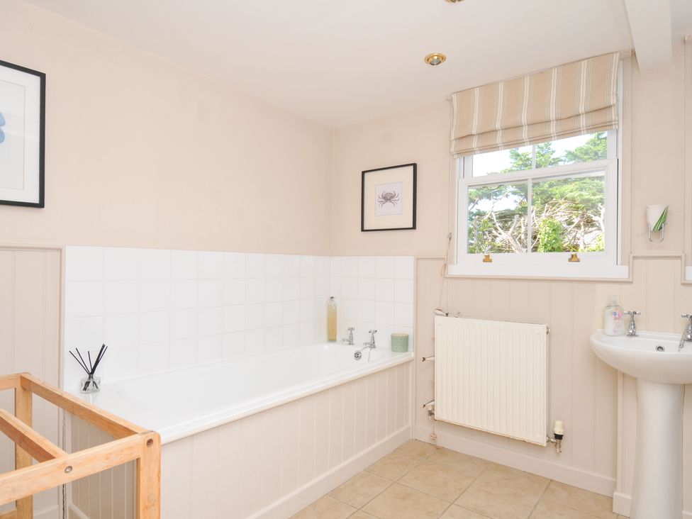 A bathroom with a bathtub, hand basin, and radiator at Sandy Lodge Rock
