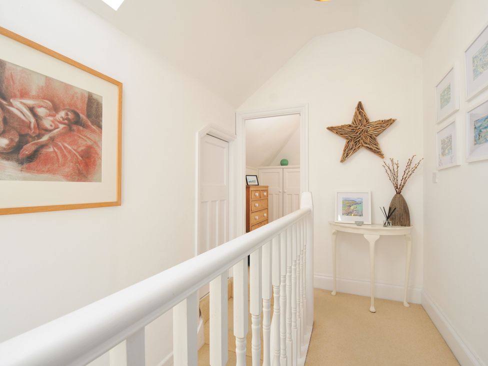 A hallway with staircase and artwork at Sandy Lodge Rock