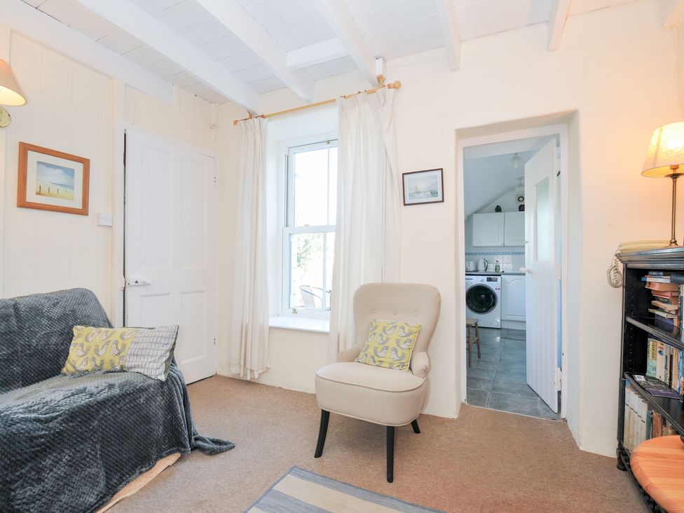 A living room with a sofa and armchair at Coppingers Cottage in Polzeath