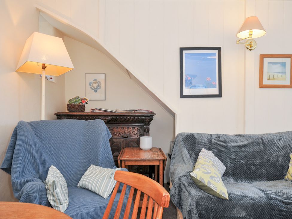 A living room with a sofa and a table at Coppingers Cottage in Polzeath