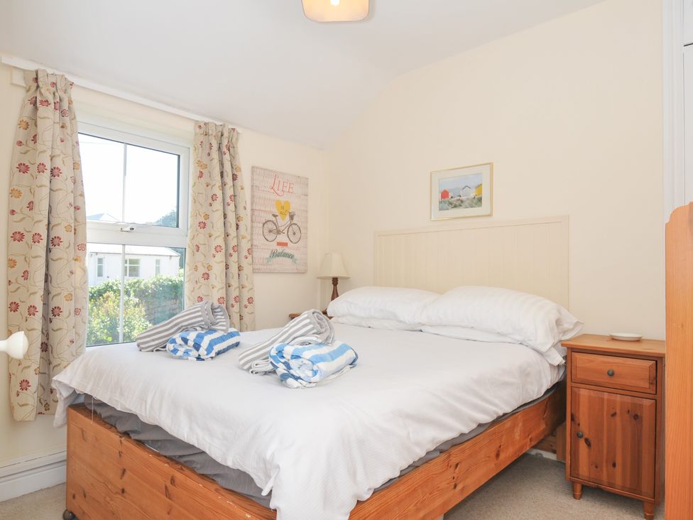 A bedroom with a bed and nightstand at Coppingers Cottage Polzeath