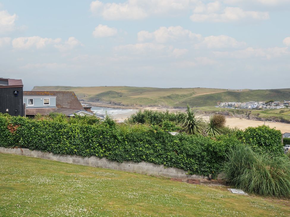 A garden with grass and a view of the coastline at Hillview in Polzeath