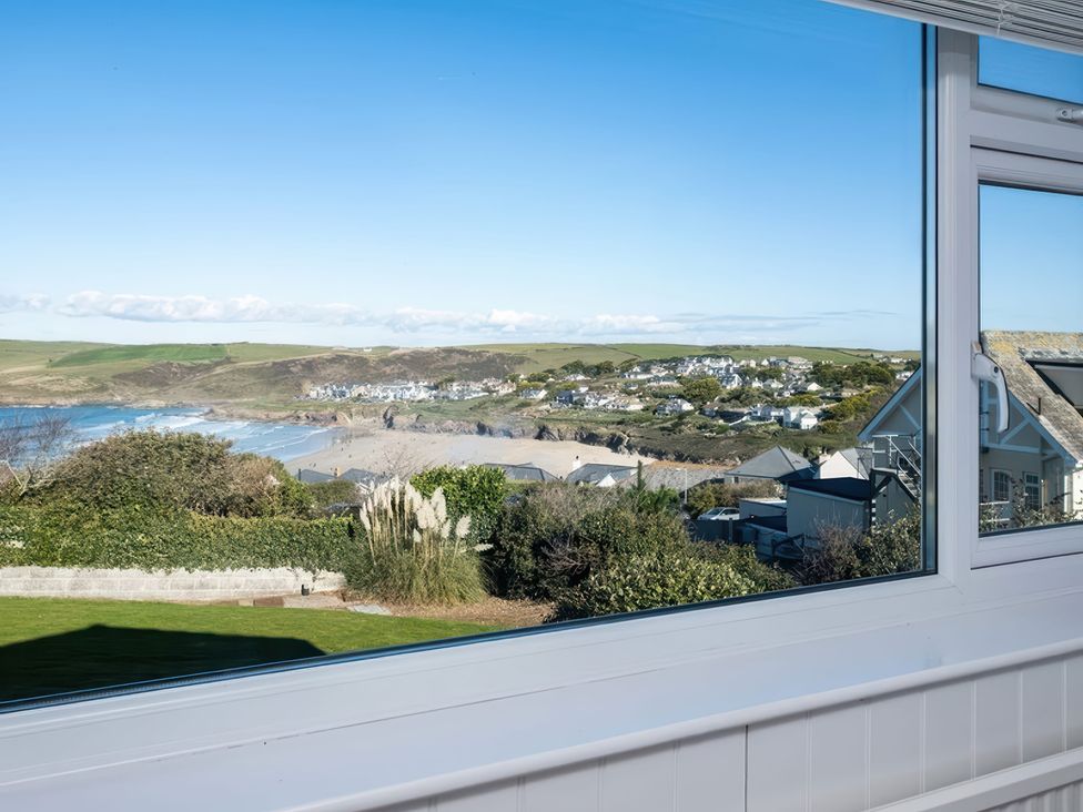 A view from a window showing a beach and landscape at Hillview in Polzeath