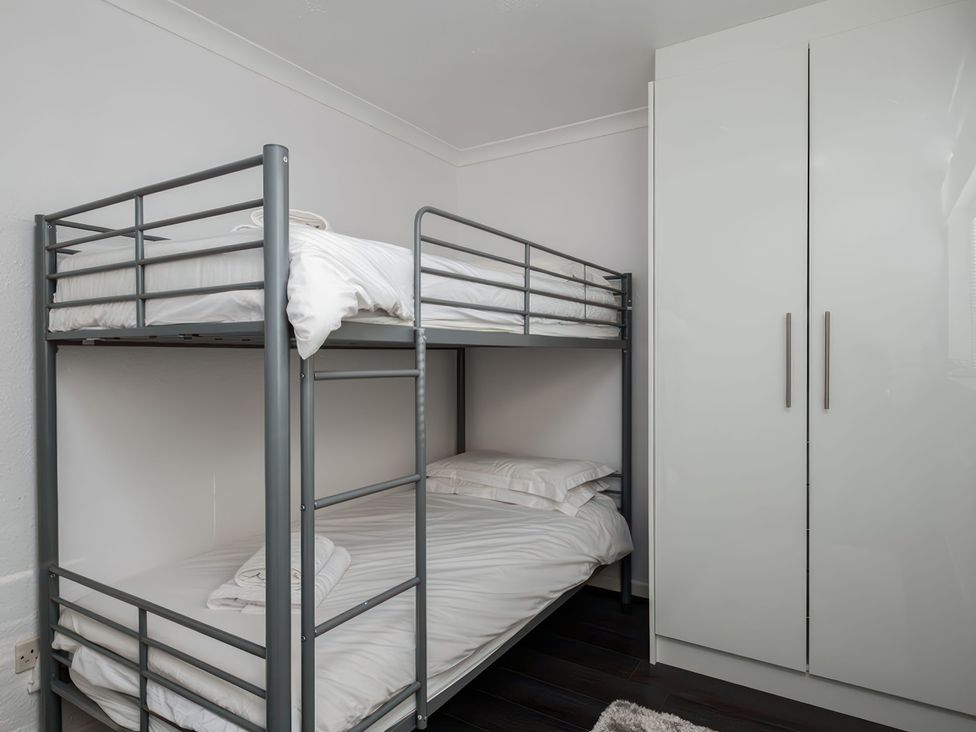 A bedroom with a bunk bed and a wardrobe at Hillview in Polzeath