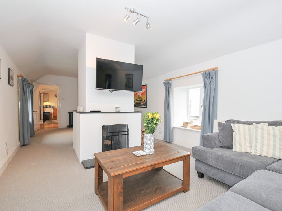 A living room with a sofa and coffee table at Orchard Cottage in Polzeath