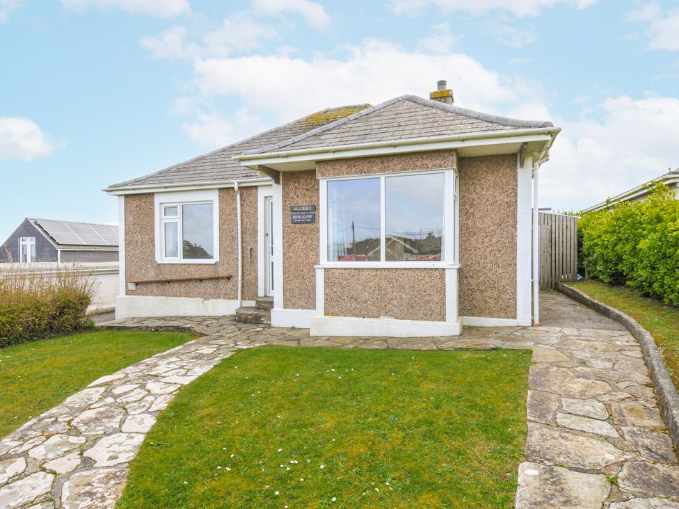 A bungalow with a stone pathway and grass at Hillcroft Bungalow in Daymer Bay