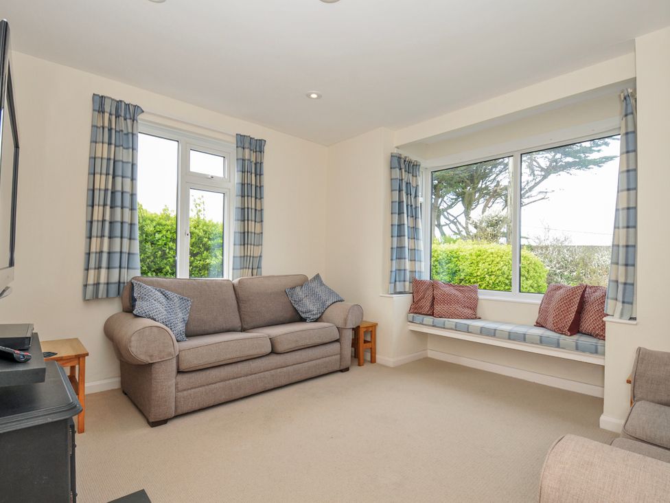 A living room with a sofa and a window at Hillcroft Bungalow Daymer Bay