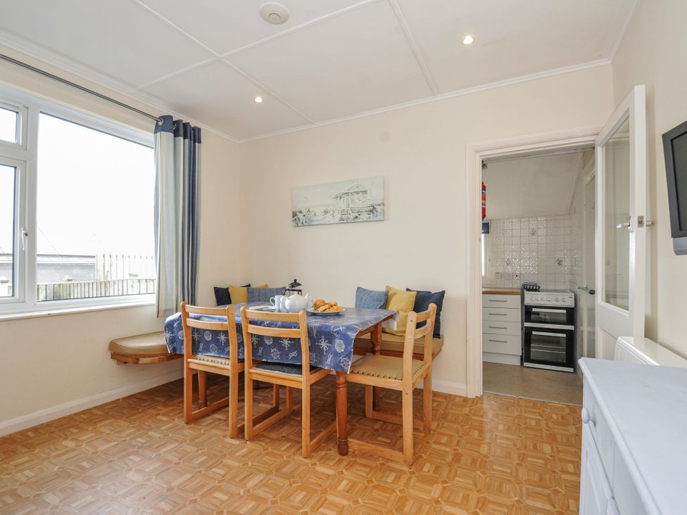 A dining room with a table and chairs at Hillcroft Bungalow Daymer Bay