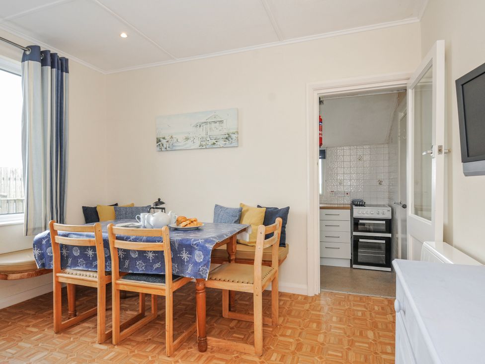 A dining room with a table and chairs at Hillcroft Bungalow Daymer Bay