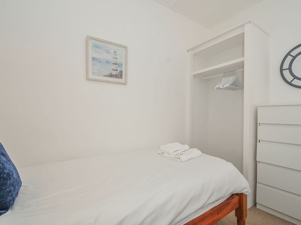 A bedroom with a bed and wardrobe at Hillcroft Bungalow Daymer Bay