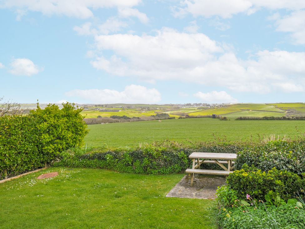 A garden with a table and grass at Hillcroft Bungalow Daymer Bay