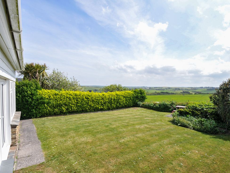 A garden with grass and hedges at Hillcroft Bungalow in Daymer Bay