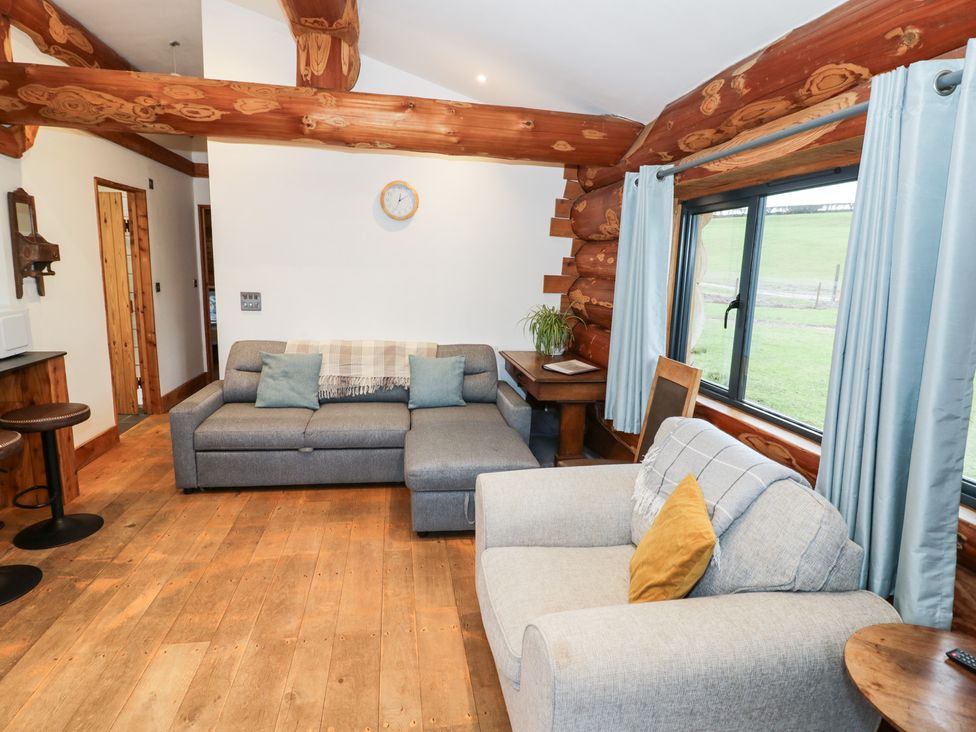 A living room with sofas and a coffee table at Cedar Cabin at Salford Court Farm Fishing Cabins near Clifton Upon Teme