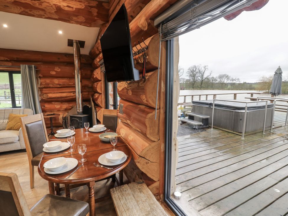 A dining area with a table and chairs at Cedar Cabin at Salford Court Farm Fishing Cabins Near Clifton Upon Teme
