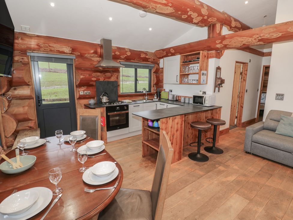 A kitchen with a dining area and seating at Cedar Cabin at Salford Court Farm Fishing Cabins Near Clifton Upon Teme