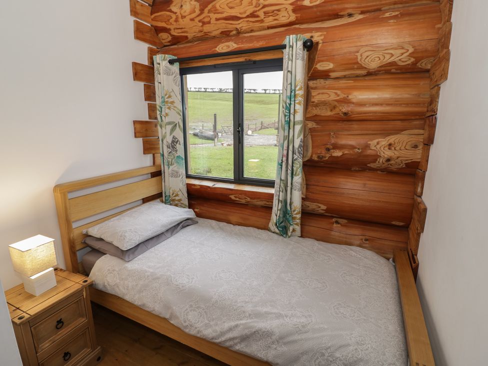 A bedroom with a single bed and a window at Cedar Cabin at Salford Court Farm Fishing Cabins near Clifton Upon Teme