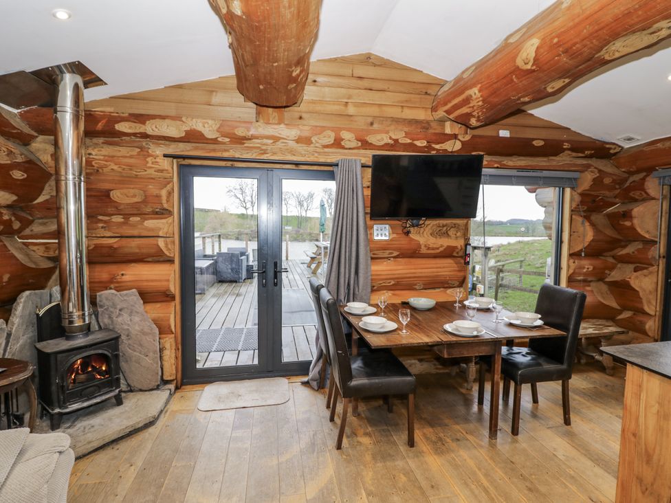 A dining room with a table and chairs at Douglas Cabin at Salford Court Farm Fishing Cabins near Clifton Upon Teme