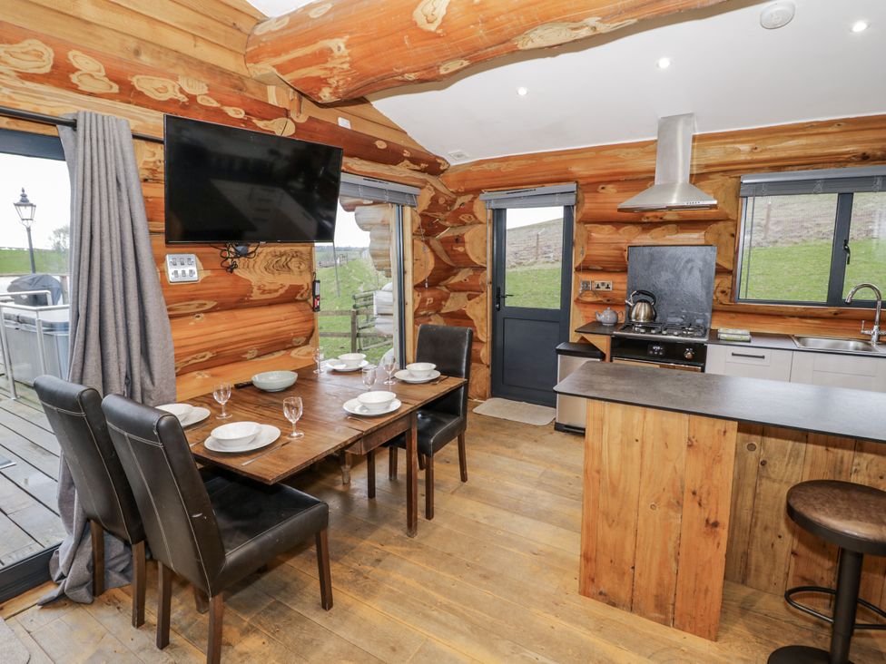A kitchen with a dining table and chairs at Douglas Cabin at Salford Court Farm Fishing Cabins Near Clifton Upon Teme
