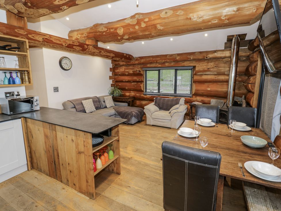 A living room with a kitchen island and dining area at Douglas Cabin at Salford Court Farm Fishing Cabins near Clifton Upon Teme