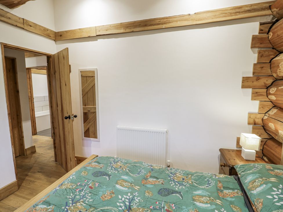 A bedroom with a bed and radiator at Douglas Cabin at Salford Court Farm Fishing Cabins near Clifton Upon Teme