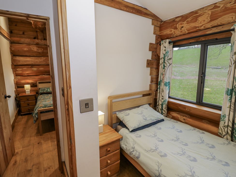 A bedroom with two beds and a window at Douglas Cabin at Salford Court Farm Fishing Cabins near Clifton Upon Teme