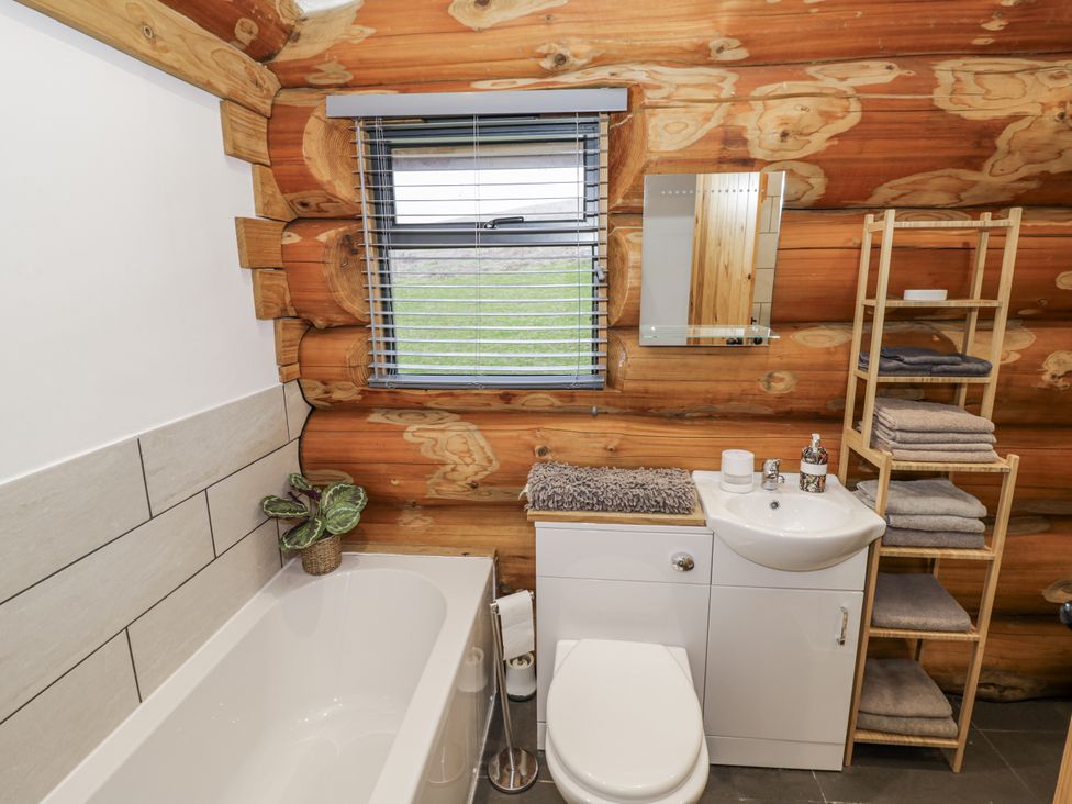 A bathroom with a bathtub, toilet, and sink at Douglas Cabin at Salford Court Farm Fishing Cabins near Clifton Upon Teme