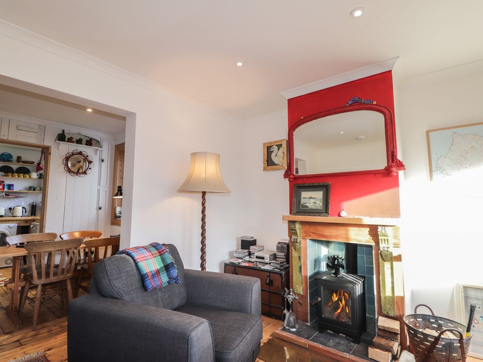 A living room with an armchair and fireplace at Free Presbyterian Manse in Kinlochbervie