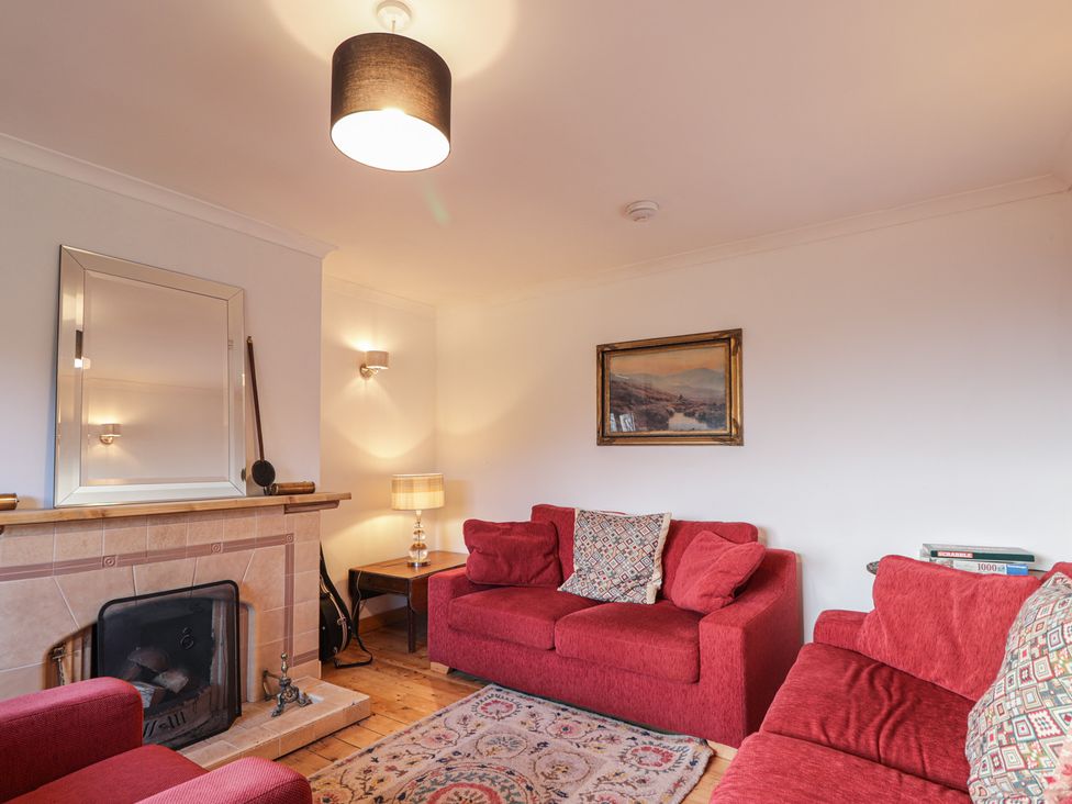 A living room with a sofa and fireplace at Free Presbyterian Manse in Kinlochbervie
