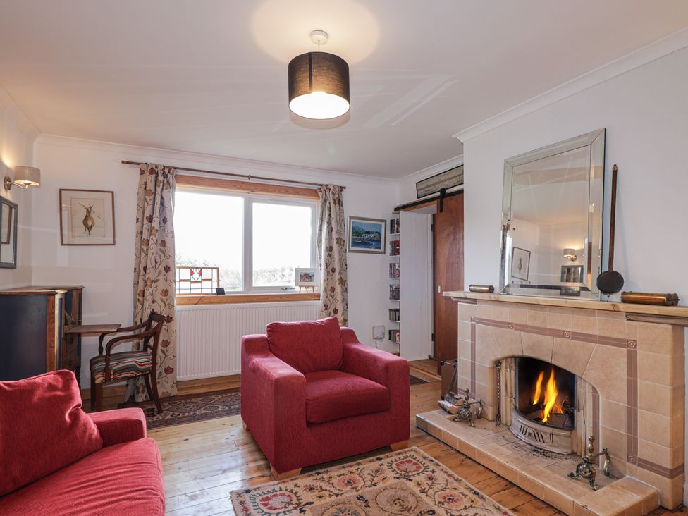 A living room with a fireplace and two armchairs at Free Presbyterian Manse in Kinlochbervie