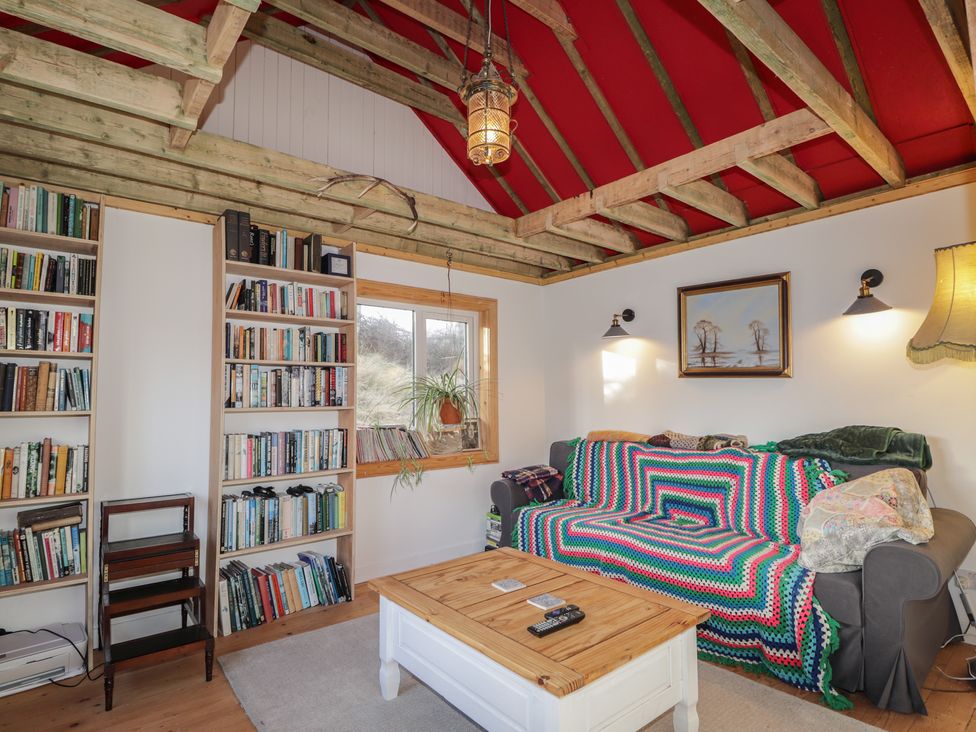 A living room with a bookshelf and a sofa at Free Presbyterian Manse in Kinlochbervie