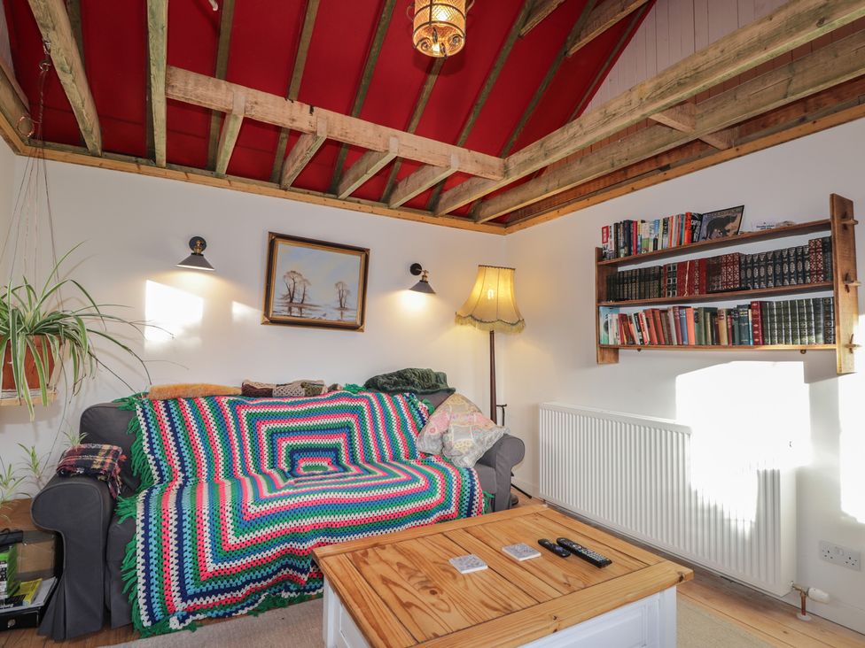 A living room with a sofa and bookshelves at Free Presbyterian Manse in Kinlochbervie