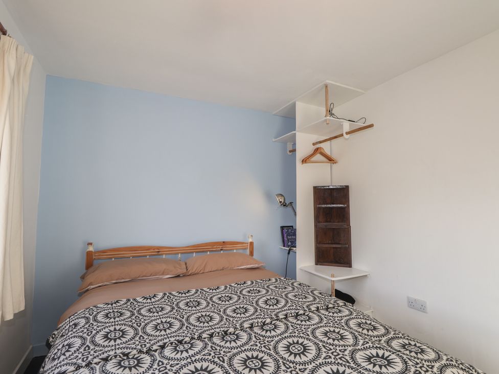 A bedroom with a bed, lamp, and shelf at Free Presbyterian Manse in Kinlochbervie