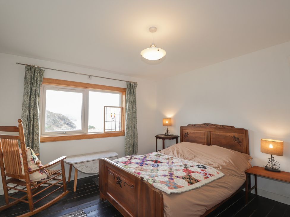 A bedroom with a bed and rocking chair at Free Presbyterian Manse in Kinlochbervie